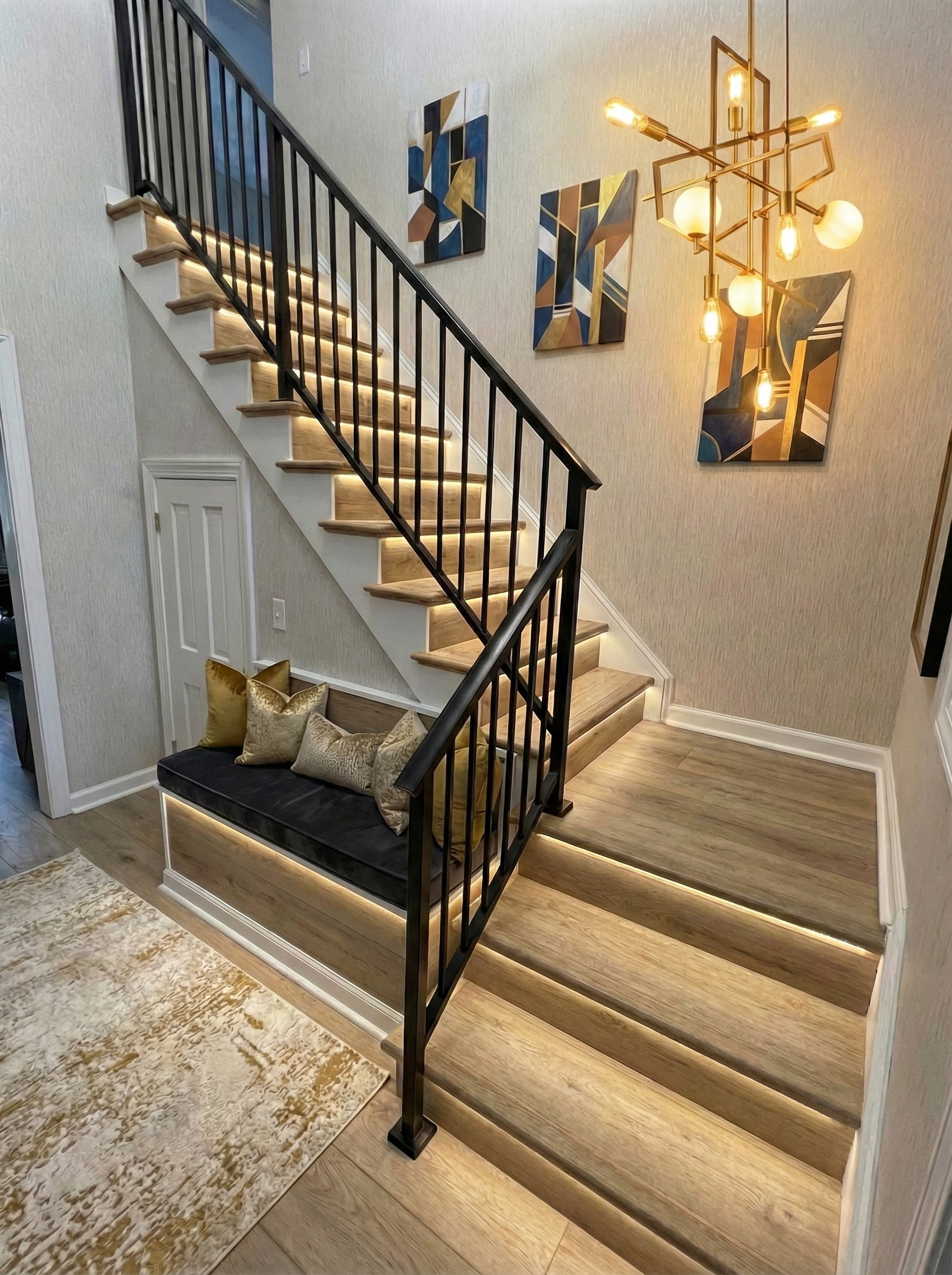 Entry staircase after renovation with wood treads and black railings