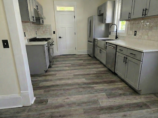Kitchen after renovation with gray cabinetry and plank flooring