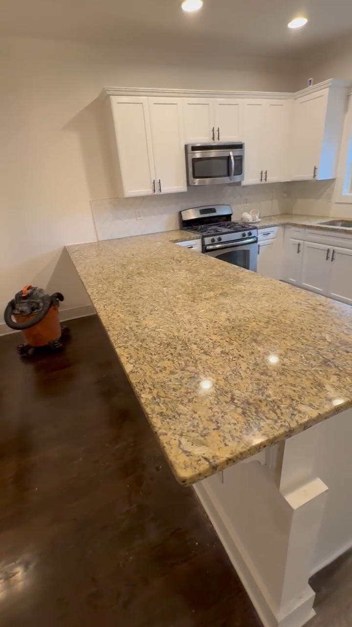 Kitchen after renovation with light cabinetry and granite countertops